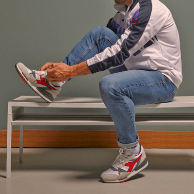 Man wearing Diadora shoes in white grey red and blue