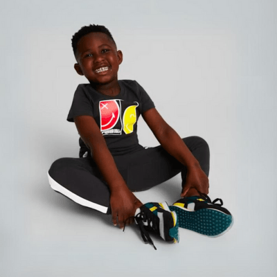 a child wearing puma future rider sneakers