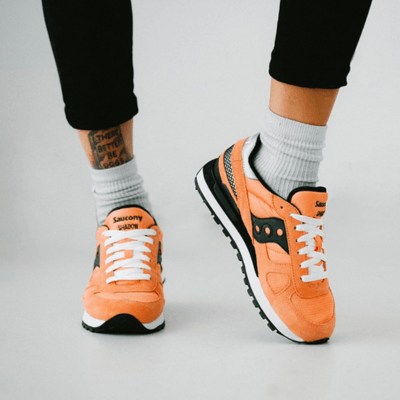 orange/black/white saucony shadow sneaker for women on feet