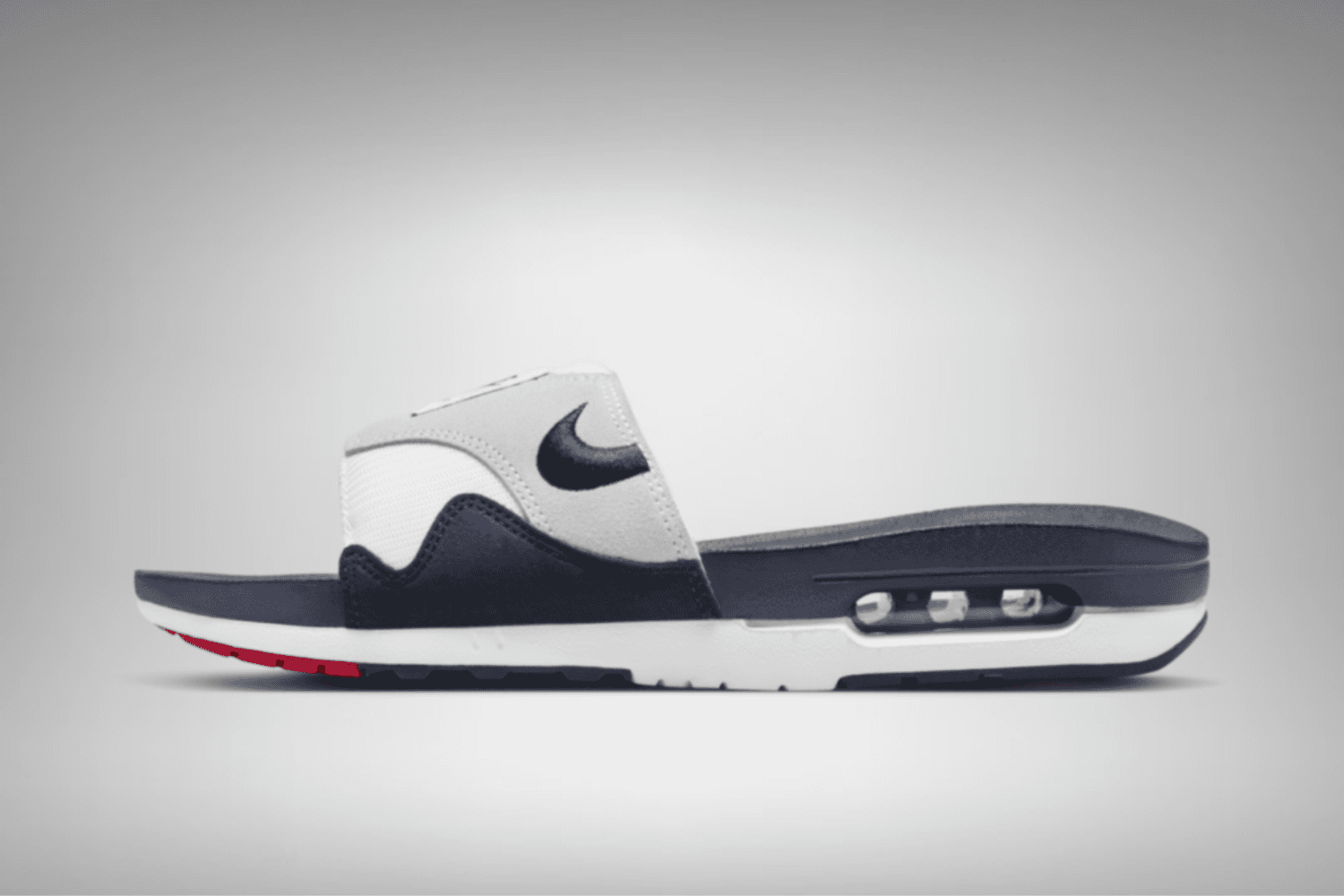 The Nike Air Max 1 Slide appears in an 'Obsidian' colorway