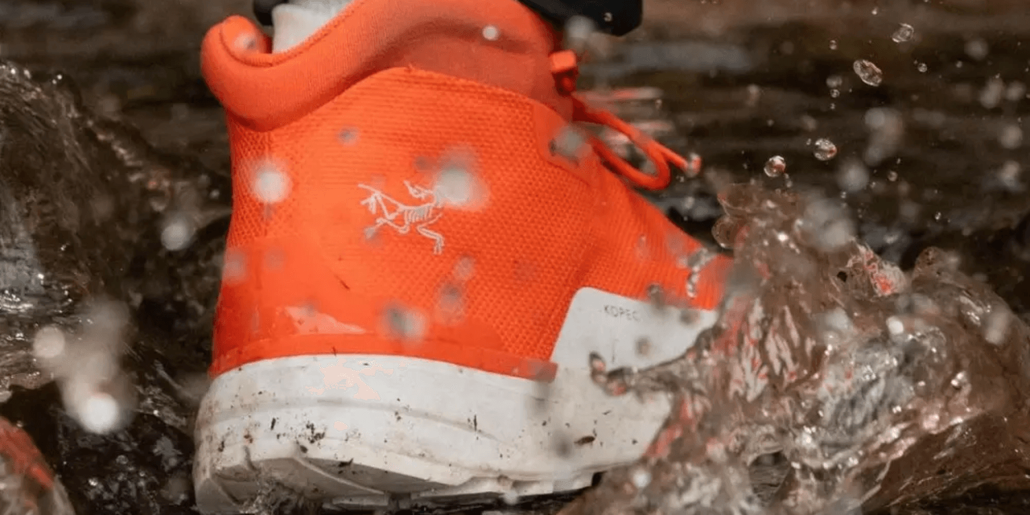 orange arc'teryx sneaker in puddle